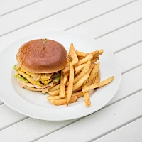 A cheeseburger with lettuce, cheese, and a beef patty on a bun, served with a generous pile of french fries on a white plate.