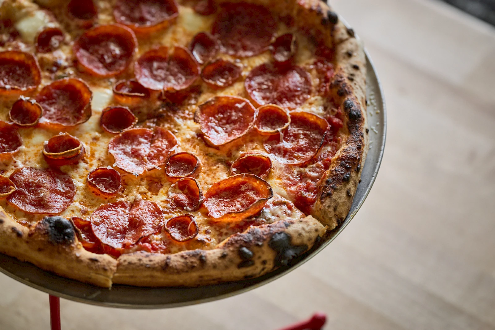 A pepperoni pizza on a round tray, crusty edges, melted cheese, and pepperoni slices baked to perfection.