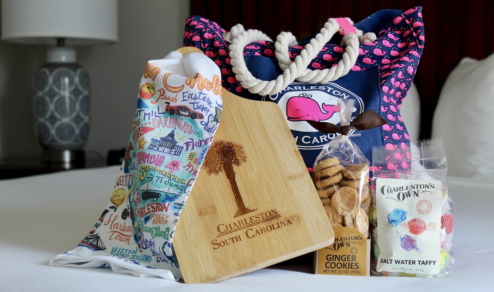 A collection of gift bags, a wooden tasting board, and assorted treats (cookies, taffy) arranged on a table. Ending with a period.