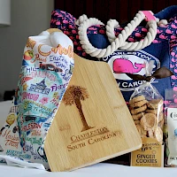 A collection of gift bags, a wooden tasting board, and assorted treats (cookies, taffy) arranged on a table. Ending with a period.