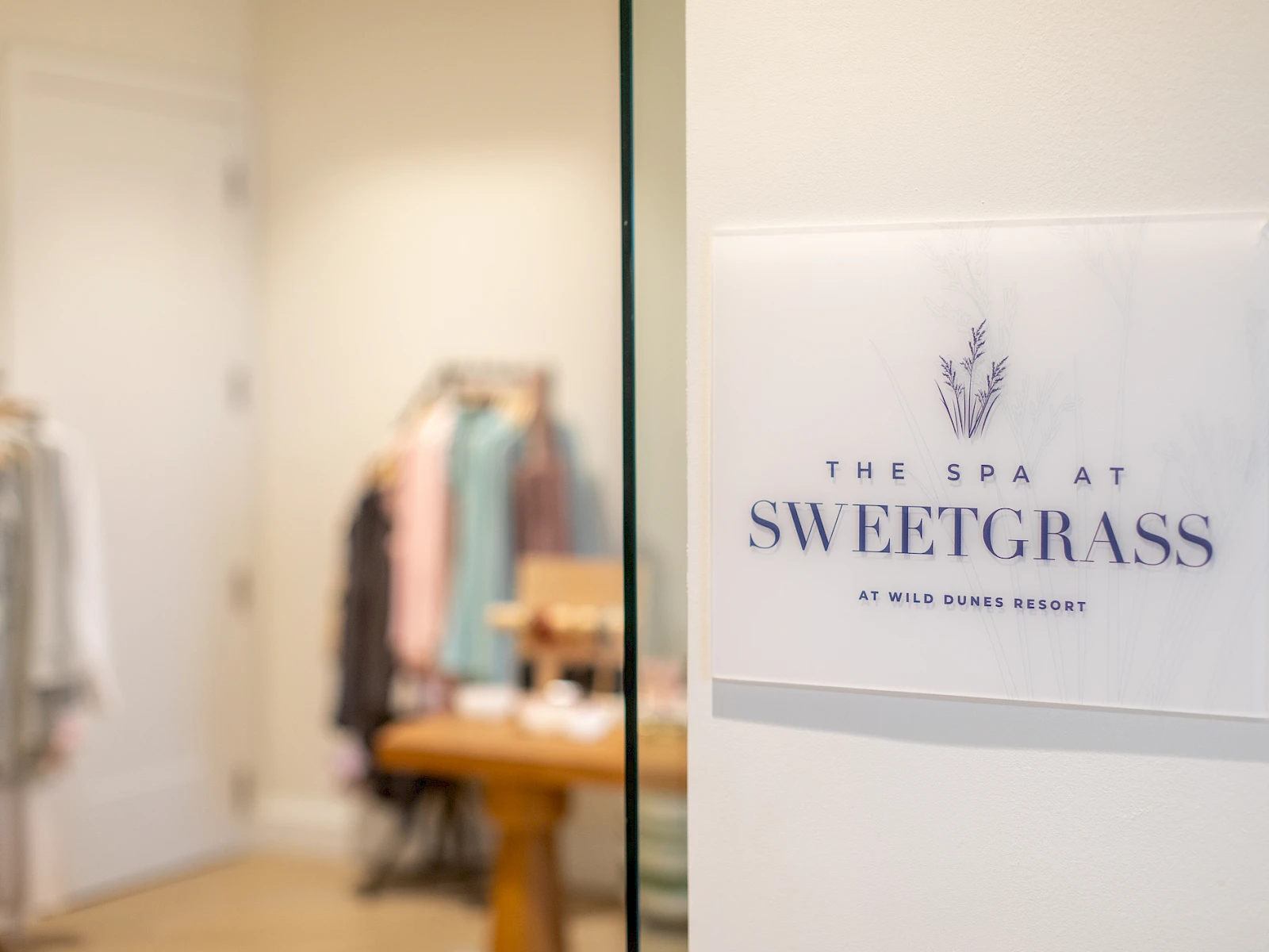 A spa sign on a glass door says “The Spa at Sweetgrass.”