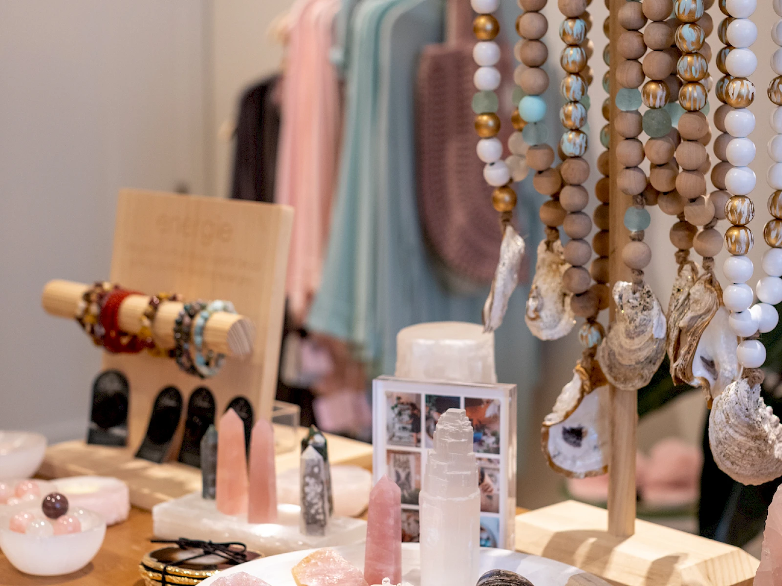 Colorful handmade jewelry display: beaded necklaces, bracelets, and soaps on a wooden table in a boutique.