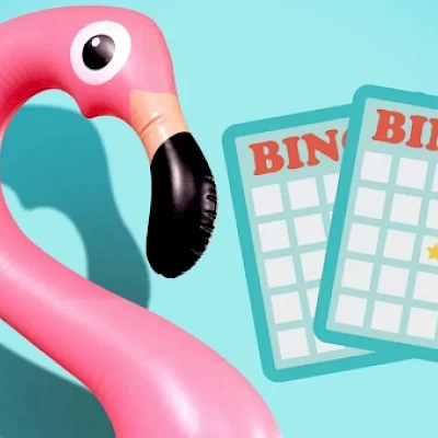 A pink flamingo inflatable float beside two BingO bingo cards on a turquoise background, hinting at tropical fun and game night vibes.